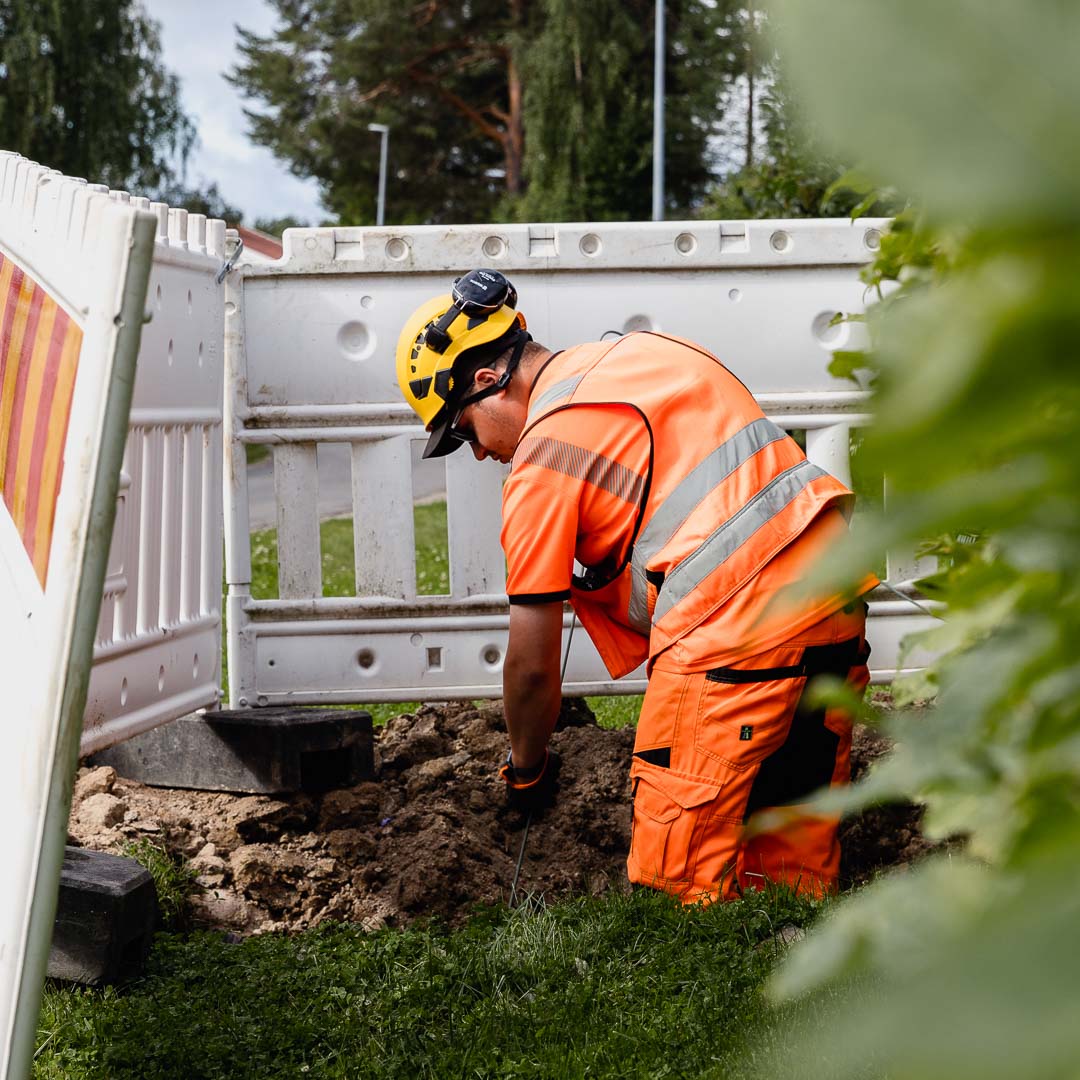 Työmies kaivaa valokuituverkkoa.